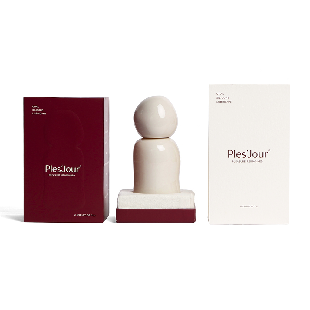 Ples’Jour Opal silicone lubricant in sculptural glass bottle displayed between boxes, showcasing luxury sexual wellness design.