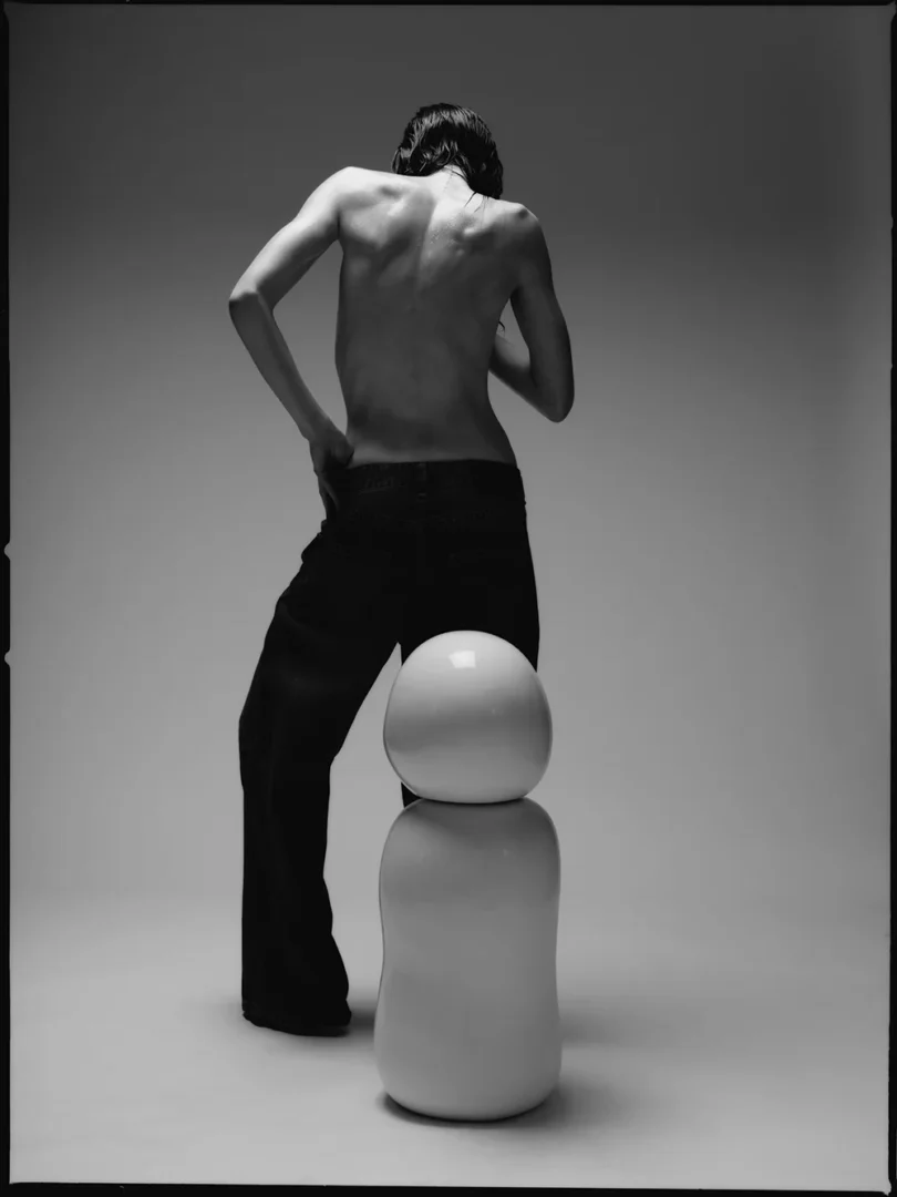 Model in denim beside a large Opal lubricant bottle for Ples’Jour, exploring body confidence, desire, and sexual wellness. Model in denim beside a large Opal lubricant bottle for Ples’Jour, exploring body confidence, desire, and sexual wellness.